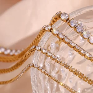 Close-up of 18K gold-plated tennis bracelets with sparkling cubic zirconia stones, elegantly displayed on a crystal glass surface.