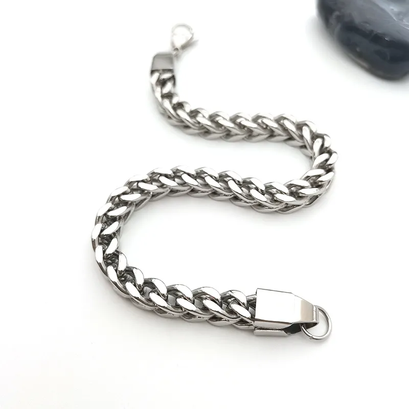 A stainless steel thick curb chain bracelet with interlocking links, a polished silver-tone finish, and a secure clasp, displayed against a white background with a black stone.
