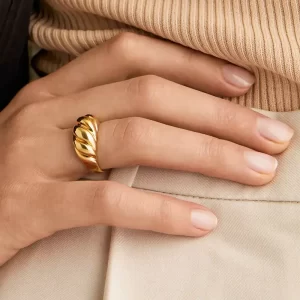 Gold chunky twist ring worn on a hand, highlighting its modern design and smooth finish.