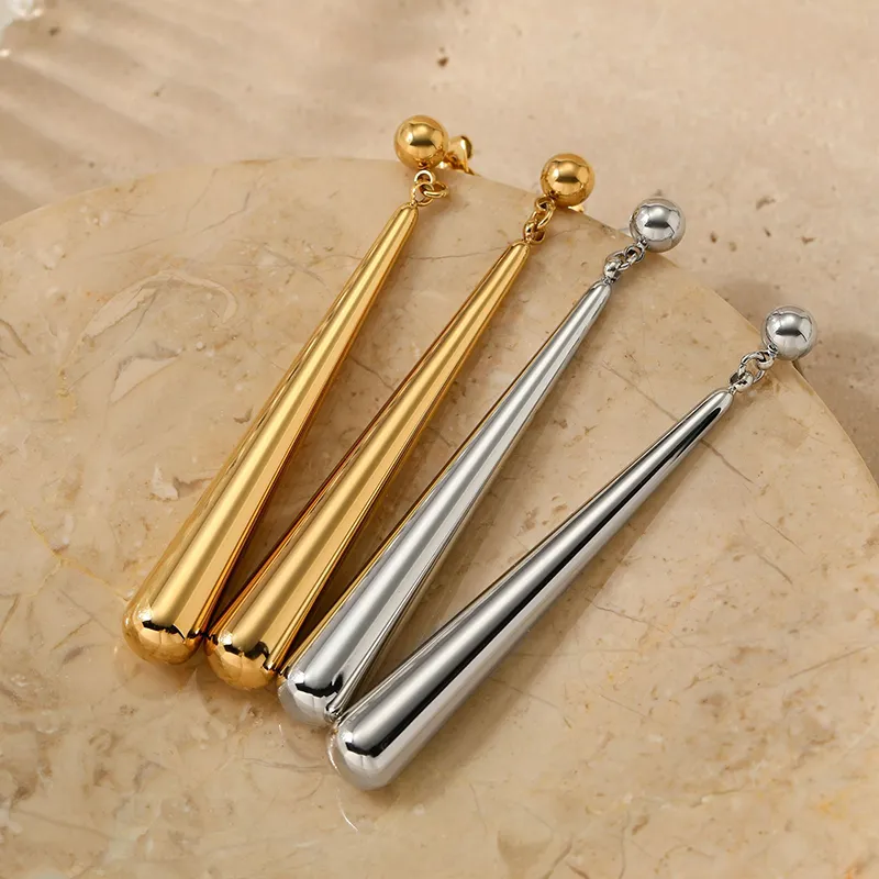 A pair of gold and silver spike earrings with a sleek design and polished finishes, featuring elongated spikes.