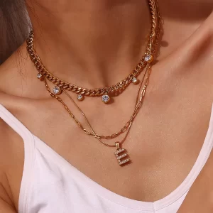 18K gold "E" initial necklace with pearl details on layered gold chains, featuring sparkling crystals, waterproof and durable.