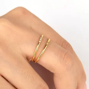 Gold double band ring with diamonds worn on a hand, highlighting the elegant design and sparkling accents.