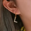 Gold hoop earrings with L-shaped AAA zircon pendant, offering a personalized and sparkling look.