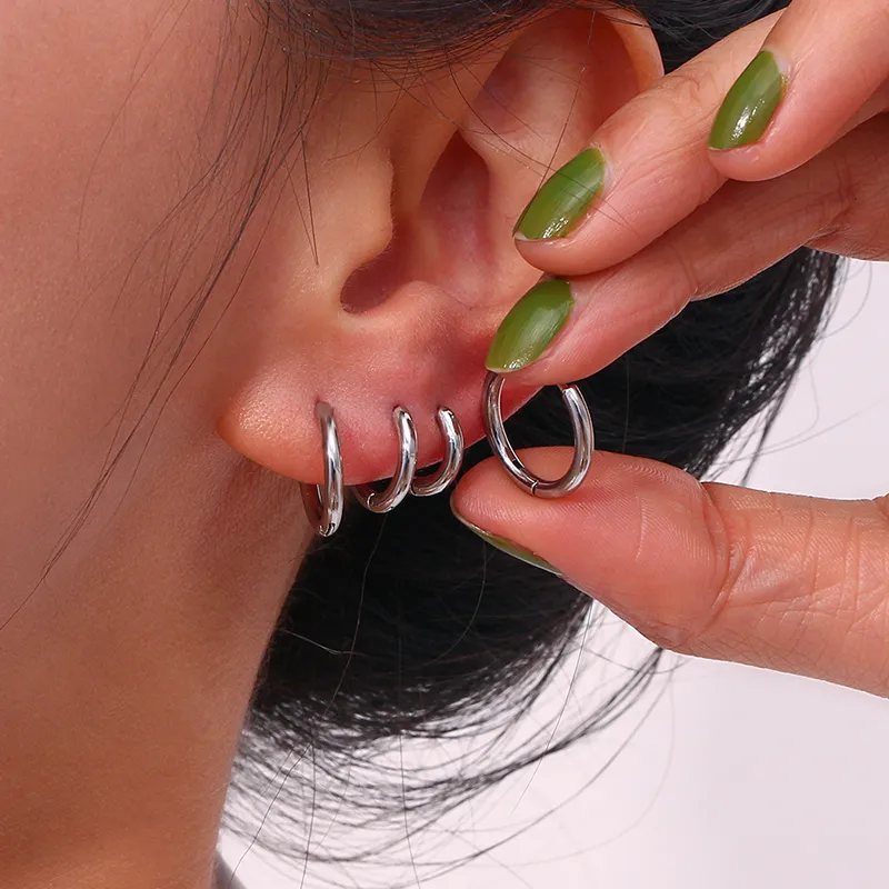Silver hoop earrings set in multiple sizes, designed for stylish ear piercings with a modern look.