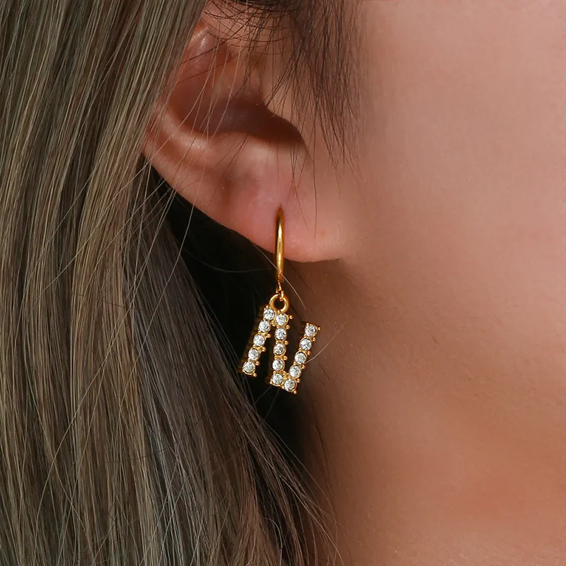 Gold hoop earrings with sparkling 'N' alphabet pendant, adorned with AAA zircon stones for a personalized and elegant look.