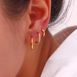 Gold hoop earrings set with plain and zircon-encrusted designs, creating an elegant and layered look.