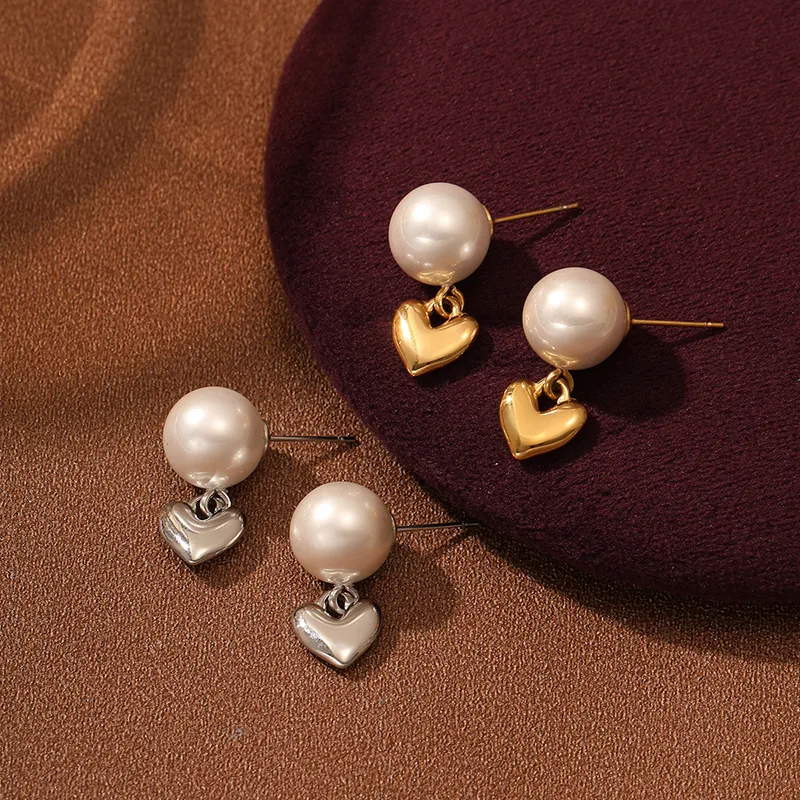 Pearl earrings with heart pendants in gold and silver, designed to be waterproof and fade-resistant.
