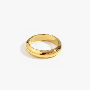 Polished gold ring with a sleek, smooth finish placed on a bright background.