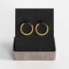 Gold hoop earrings with a sleek design, presented in a stylish gift box.